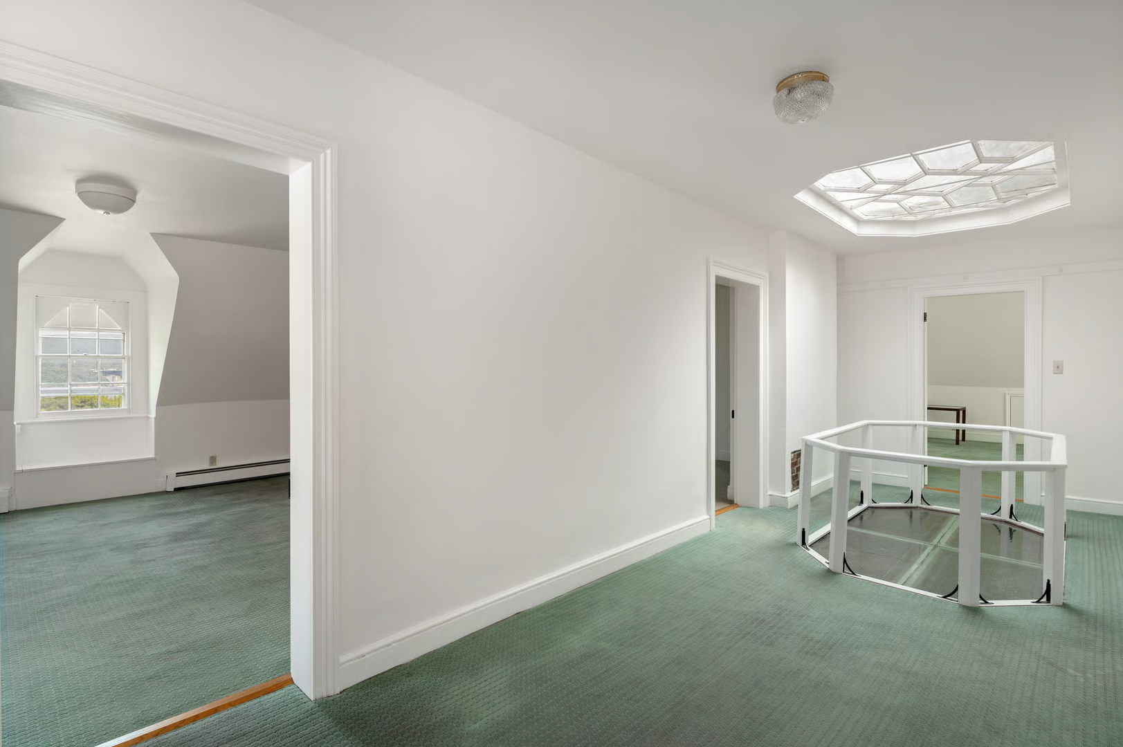 top floor hallway with wall-to-wall carpet and a skylight