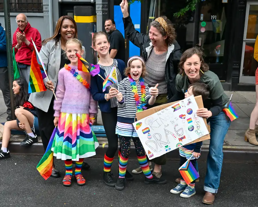 Young spectators wave rainbow flags and cheer on marchers during the Brooklyn Pride Parade.