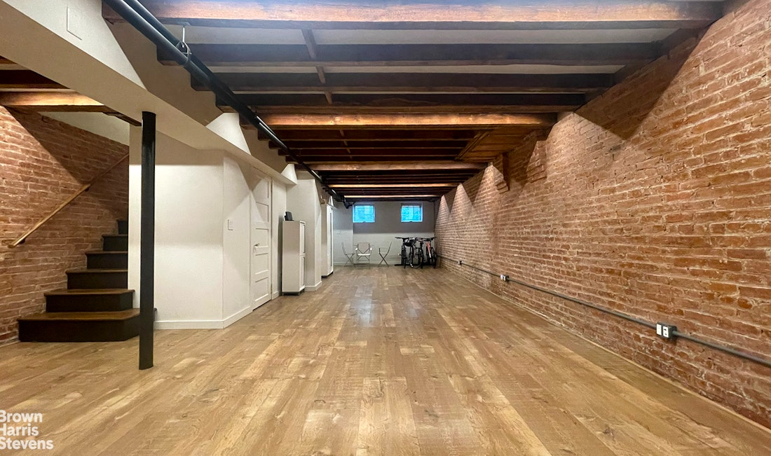basement rec room with exposed brick wall