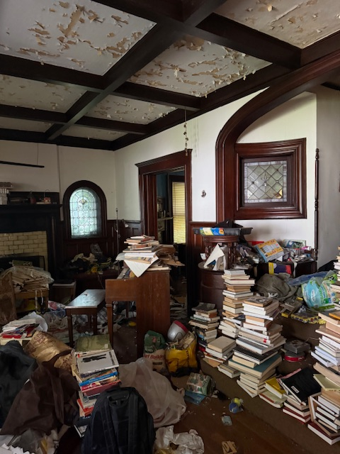 room with stained glass, mantel, beamed ceiling, peeling paint and lots of stuff