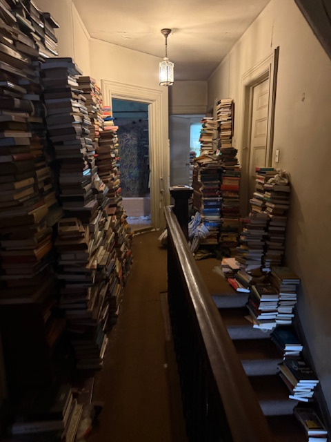hallway with piles of books