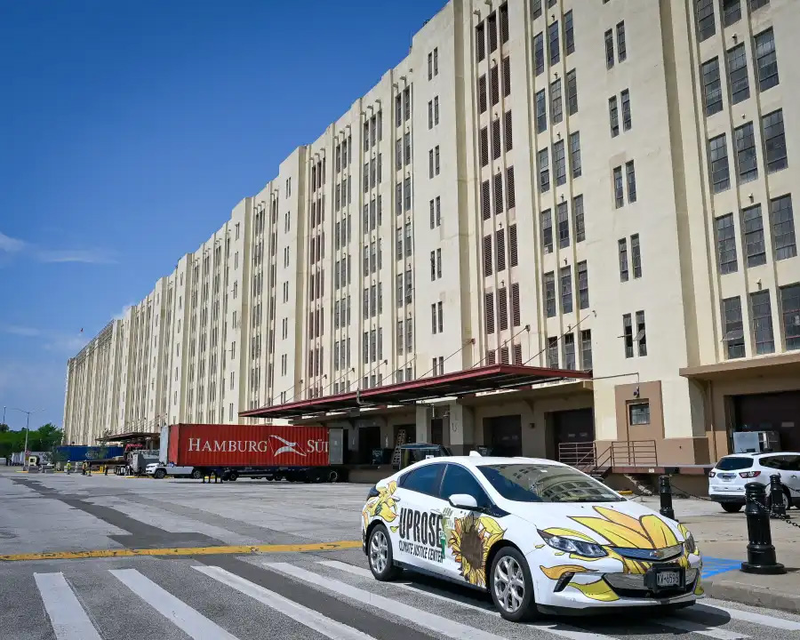 a car with a uprose logo parked in front of a building