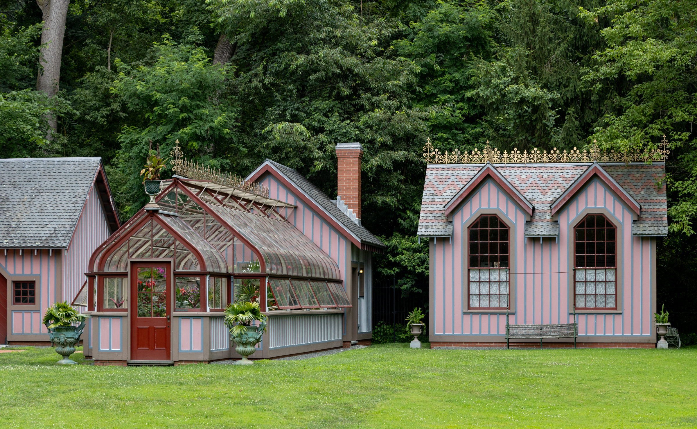 a pink studio with a slate roof and a matching greenhouse