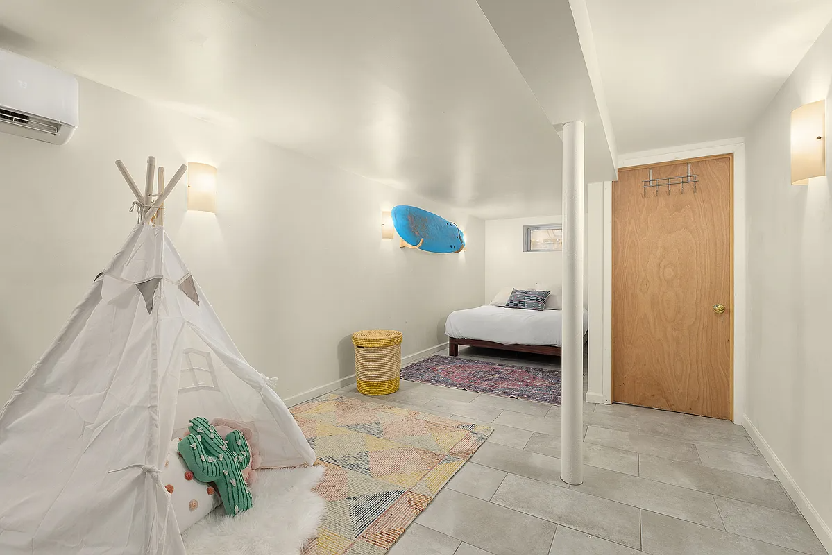 basement rec room with a tiled floor and a mini split unit