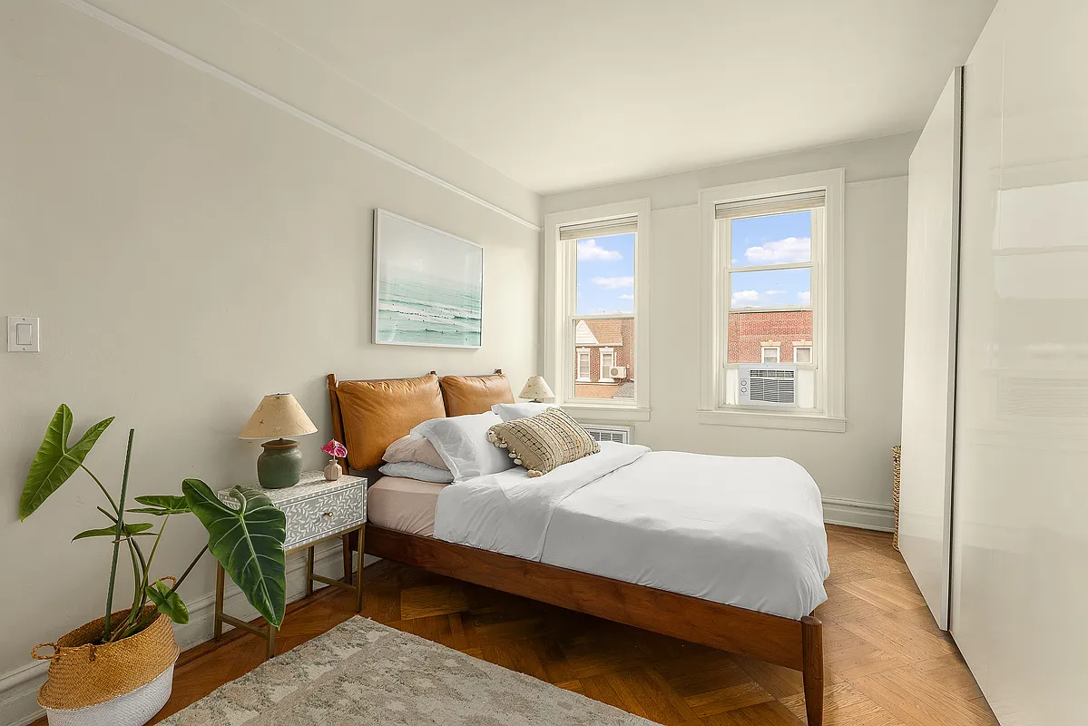 bedroom with beige walls, picture rails, wood floor