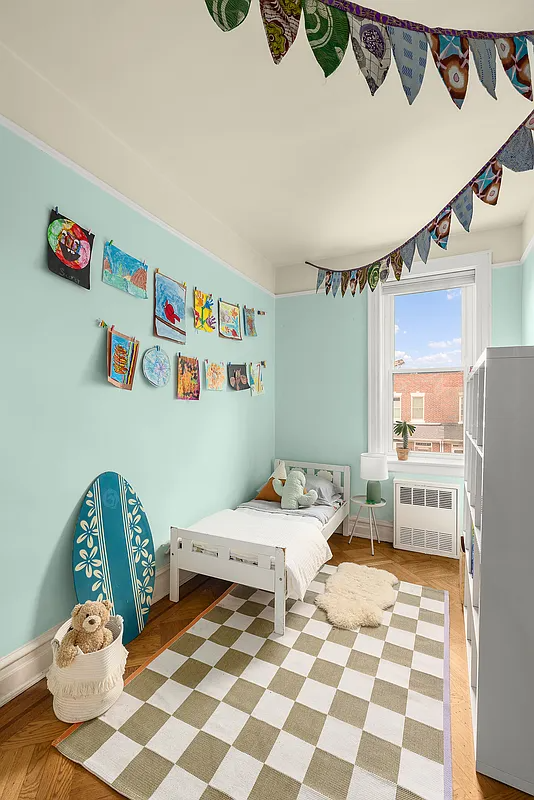 bedroom with pale blue walls, picture rails and one window
