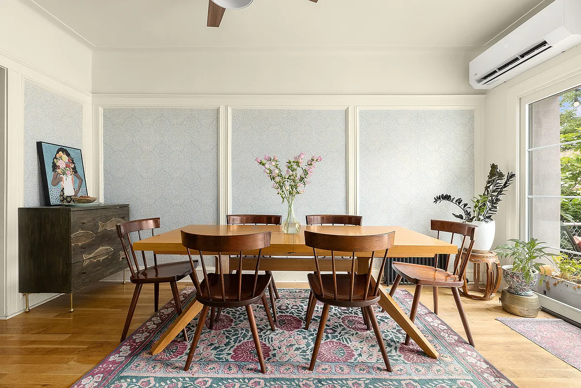 dining area with pale blue wallpaper inserts into wainscoting, a ceiling fan, and a mini split unit