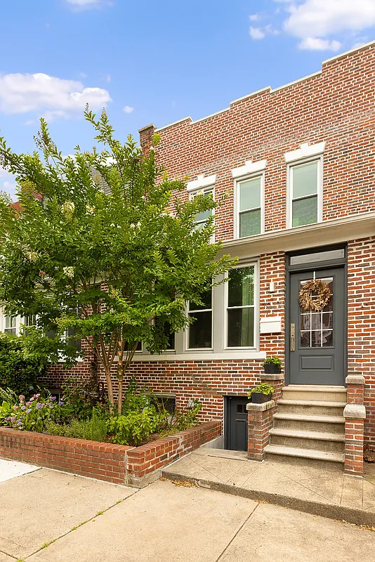 brick row house exterior with low stoop and raised brick planting bed