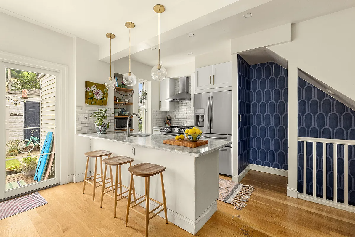 kitchen with peninsula with bar seating, white cabinets, and white subway tile