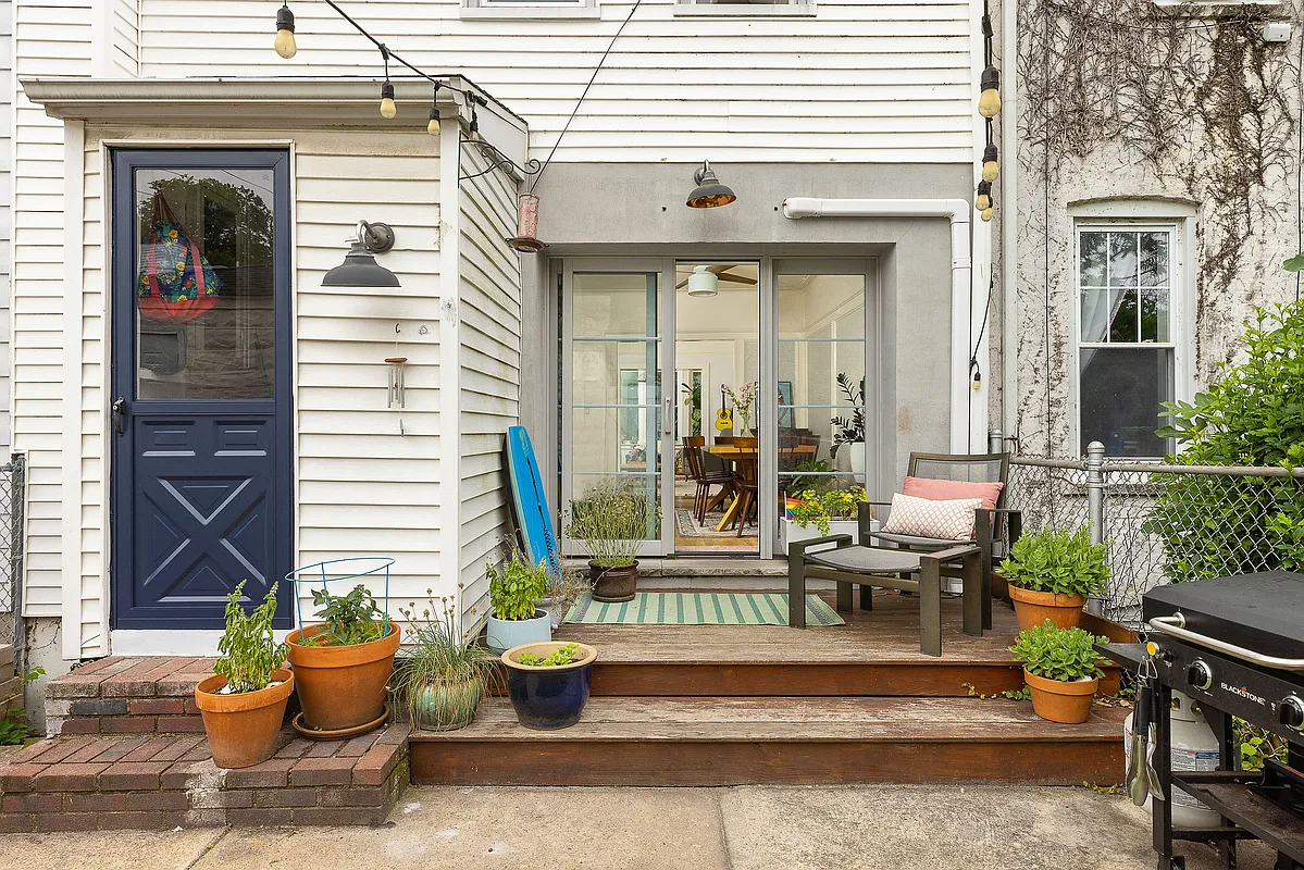 rear of house with view of attached shed and a small wood deck off the dining area