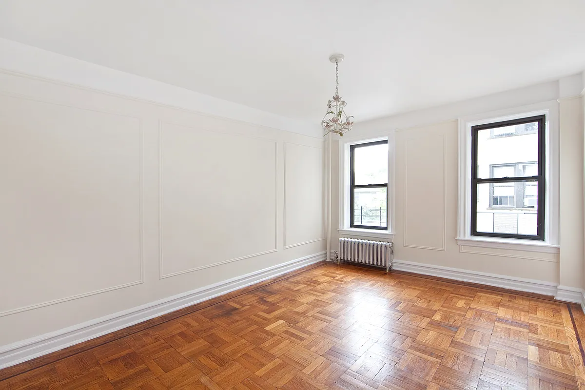 bedroom with wood floor, wall moldings, picture rails
