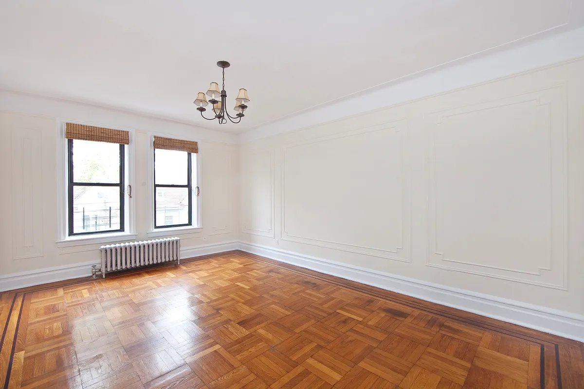 bedroom with wood floor, wall moldings, picture rails