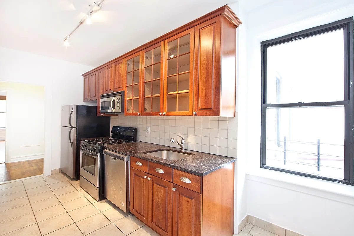 kitchen with tile floor, wood cabinets, a dishwasher