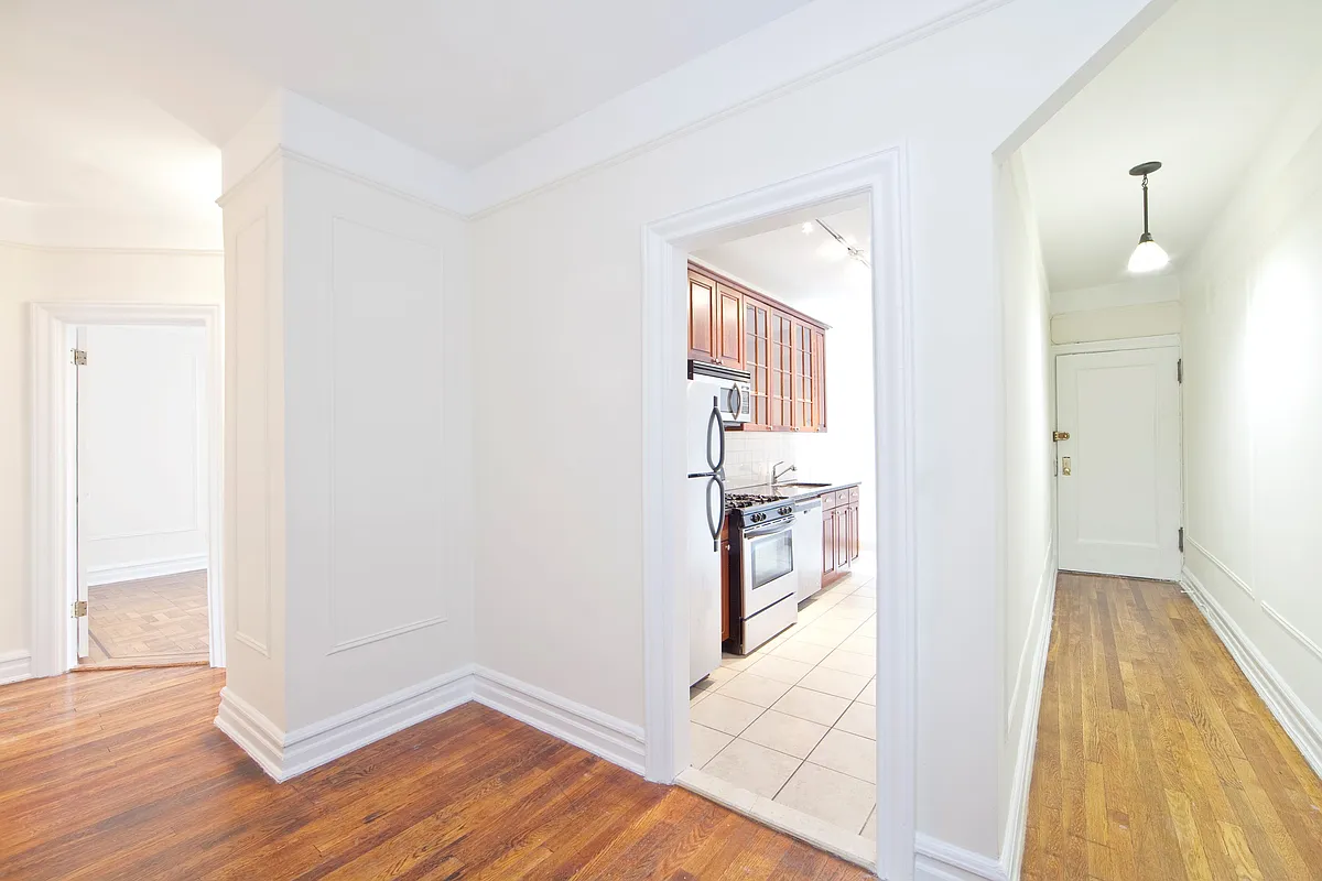 view to entry hall with a wood floor and a glimpse of the kitchen with a tile floor
