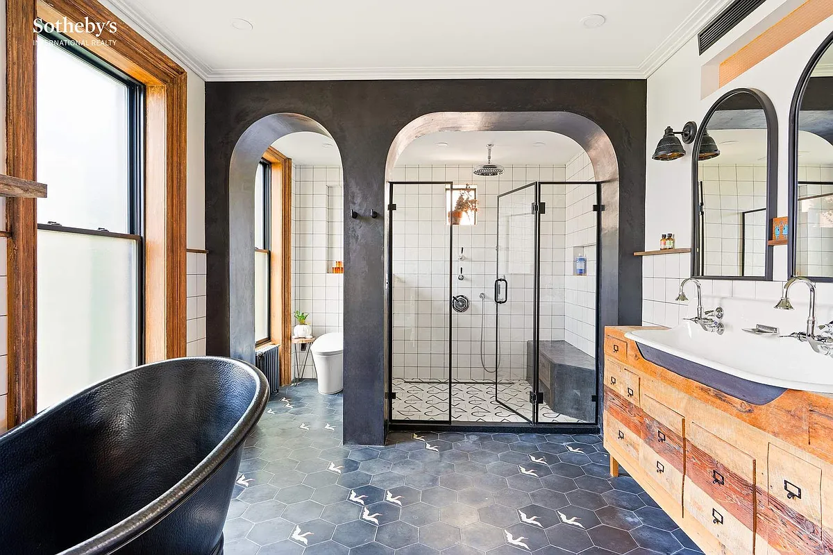 bathroom with a soaking tub, black painted wall with arched openings leading to walk-in shower and a toilet room