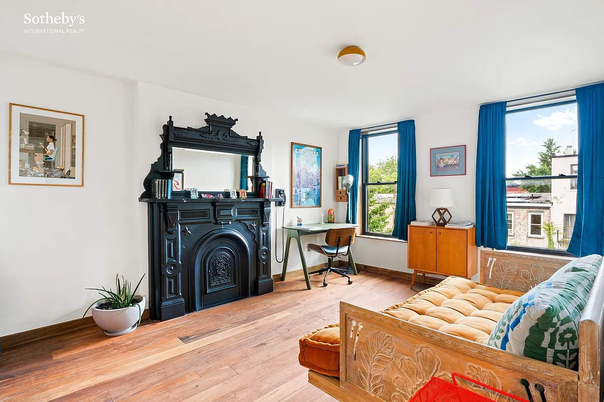 bedroom set up as a den with a black mantel