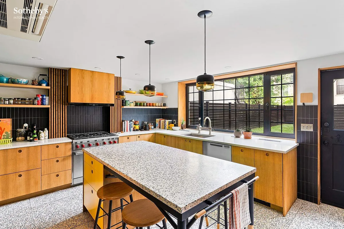 kitchen with light wood cabinets, black wall tile
