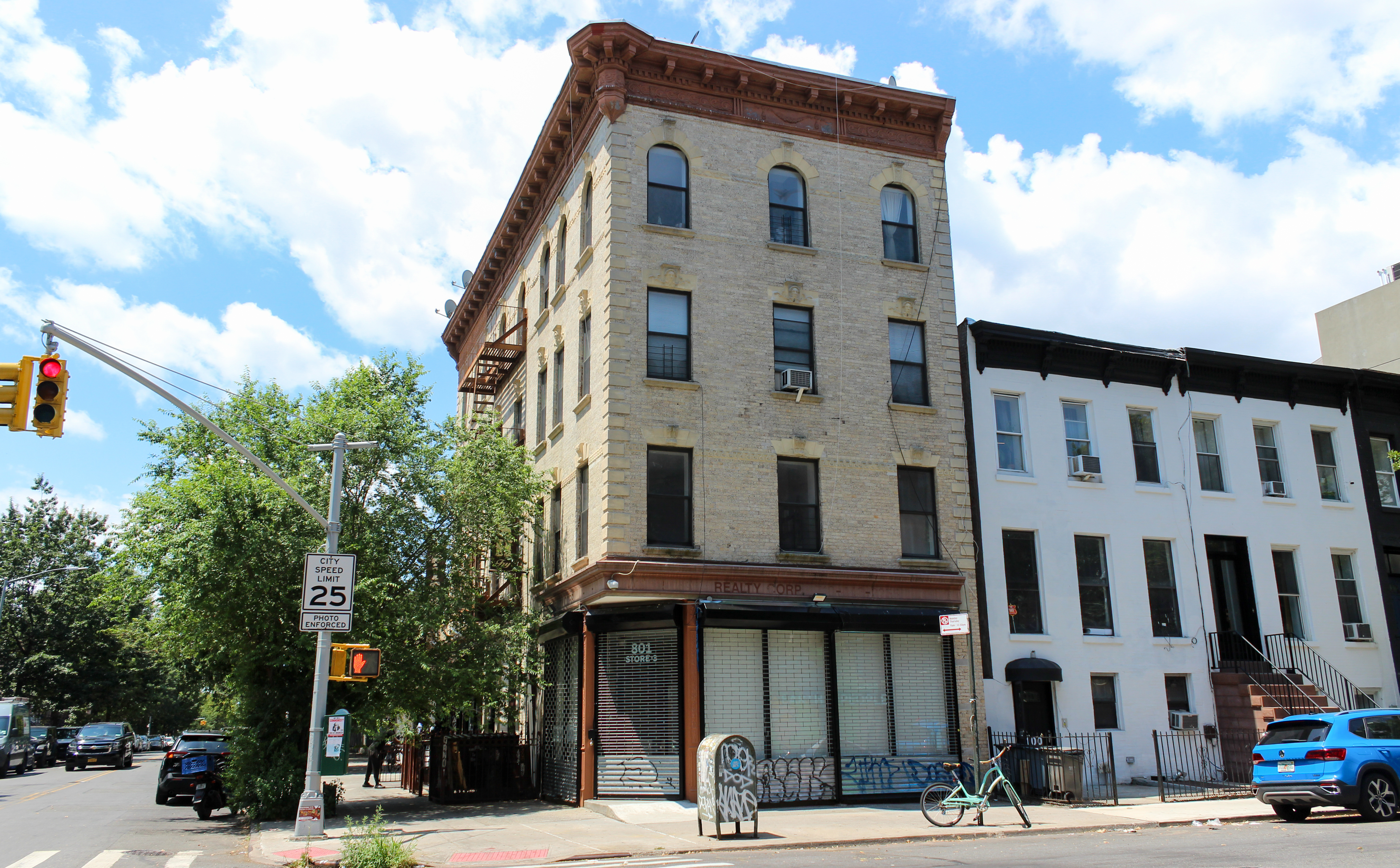 pale brick corner building with a storefront with papered over windows