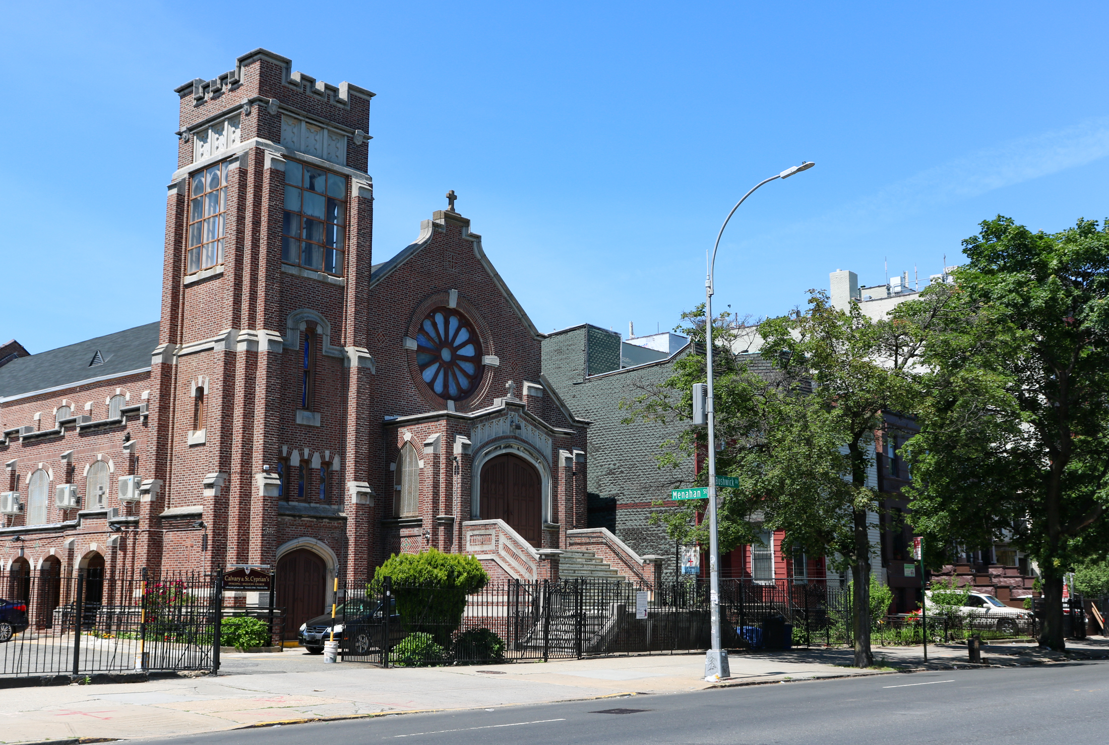 brick exterior of a church with low scale buildings adjacent