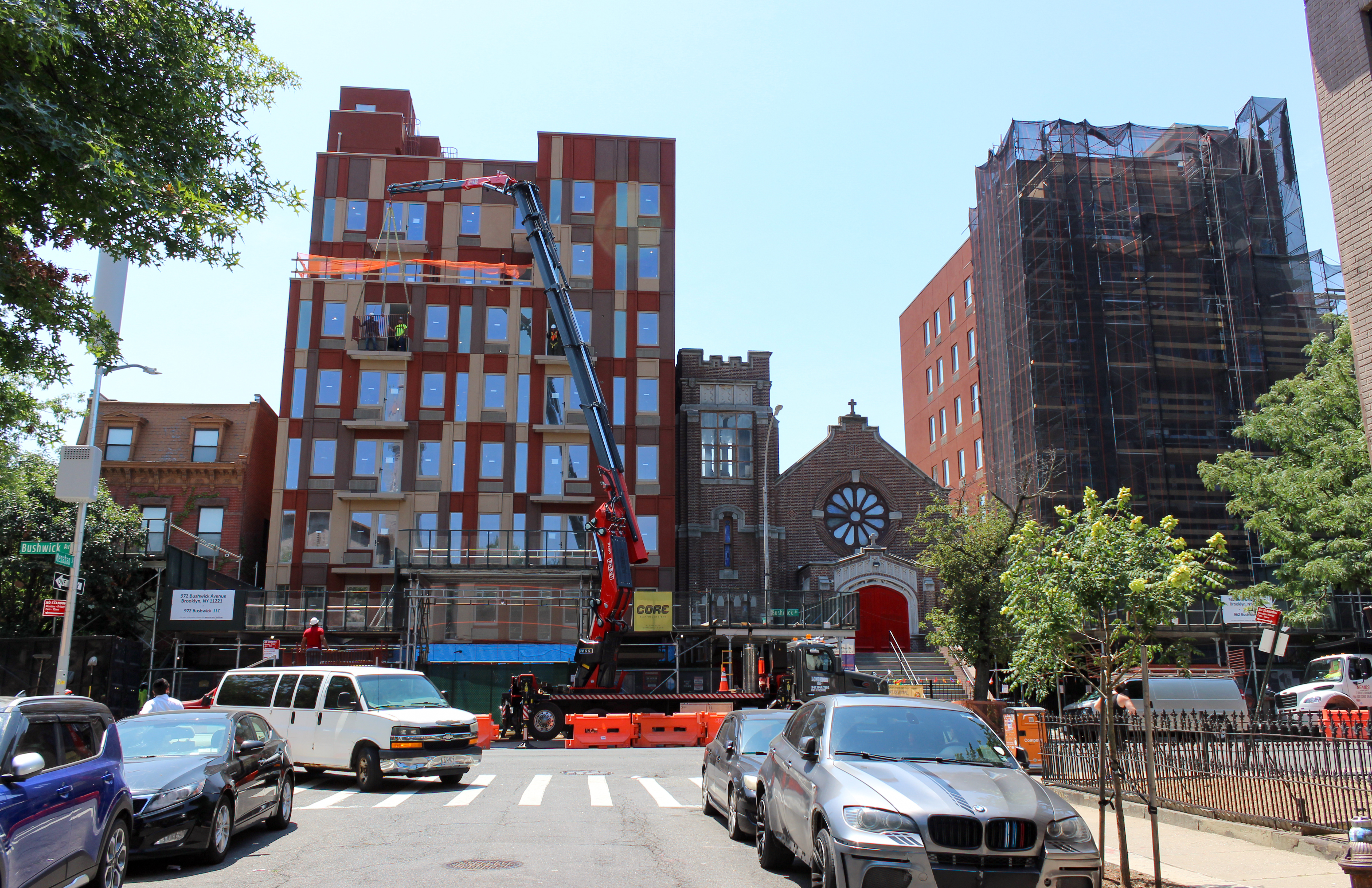 a crane in front of a church with buildings under construction on either side