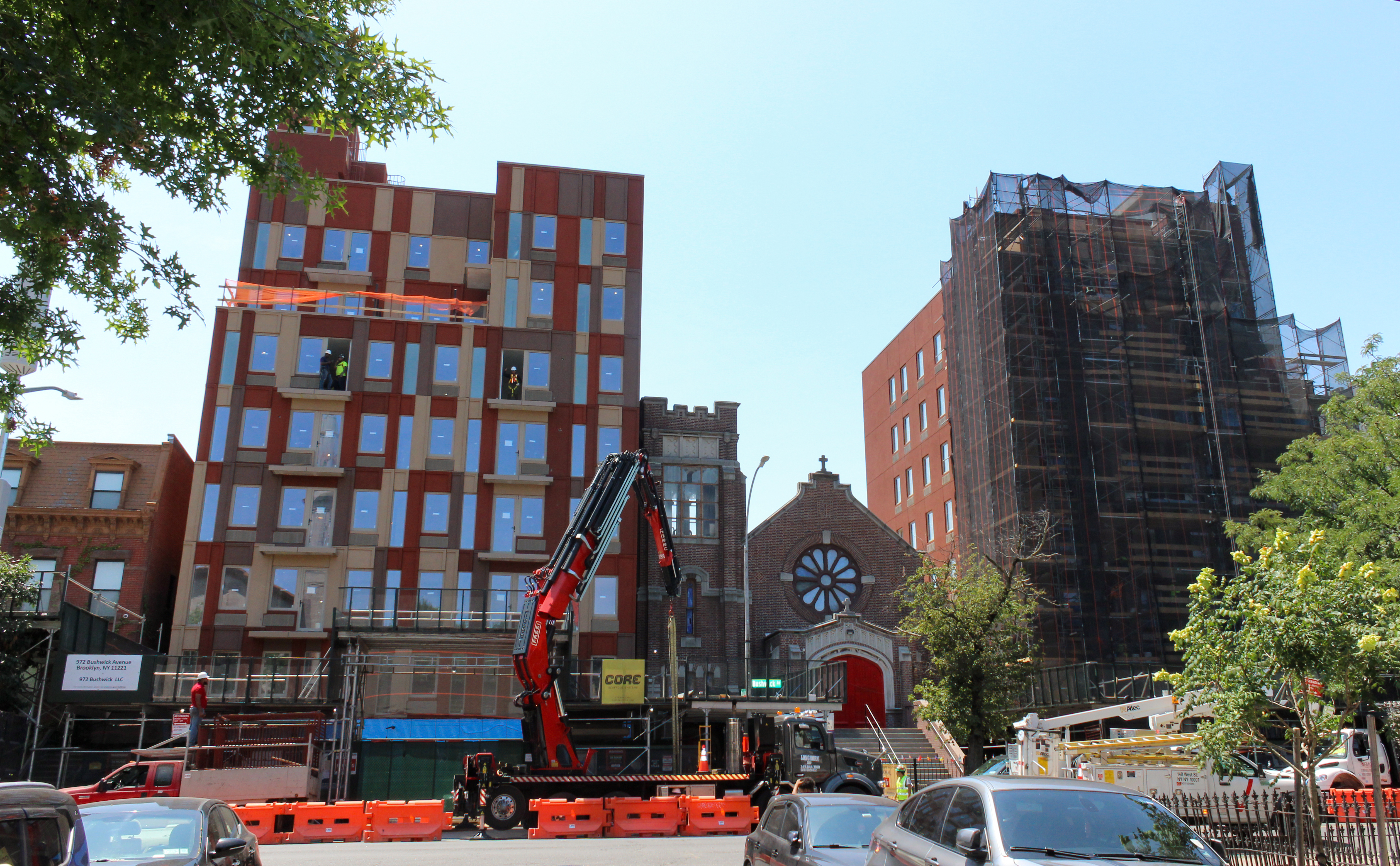 a crane in front of a church with buildings under construction on either side