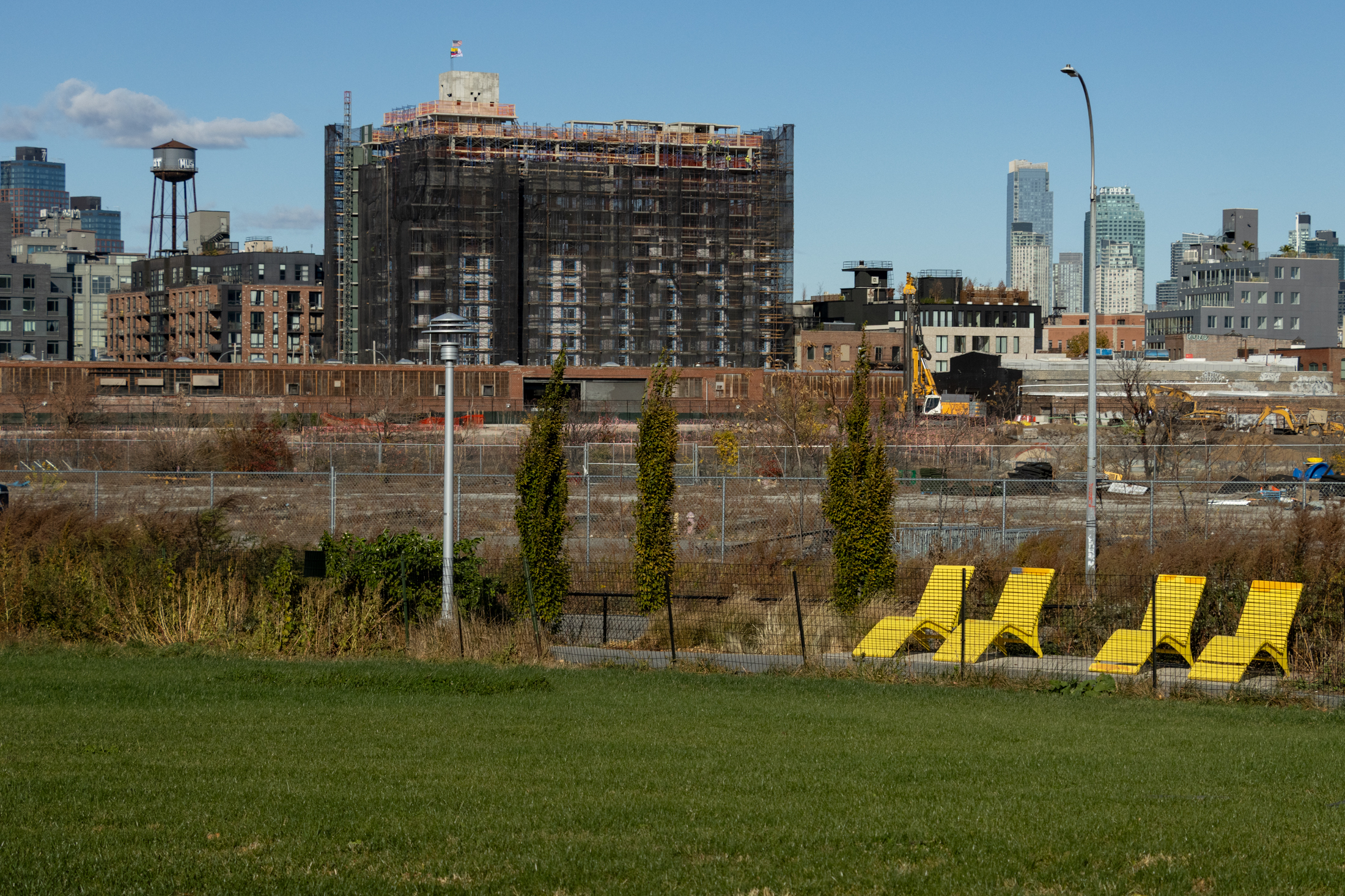 yellow chairs near a stretch of lawn with buildings in the background