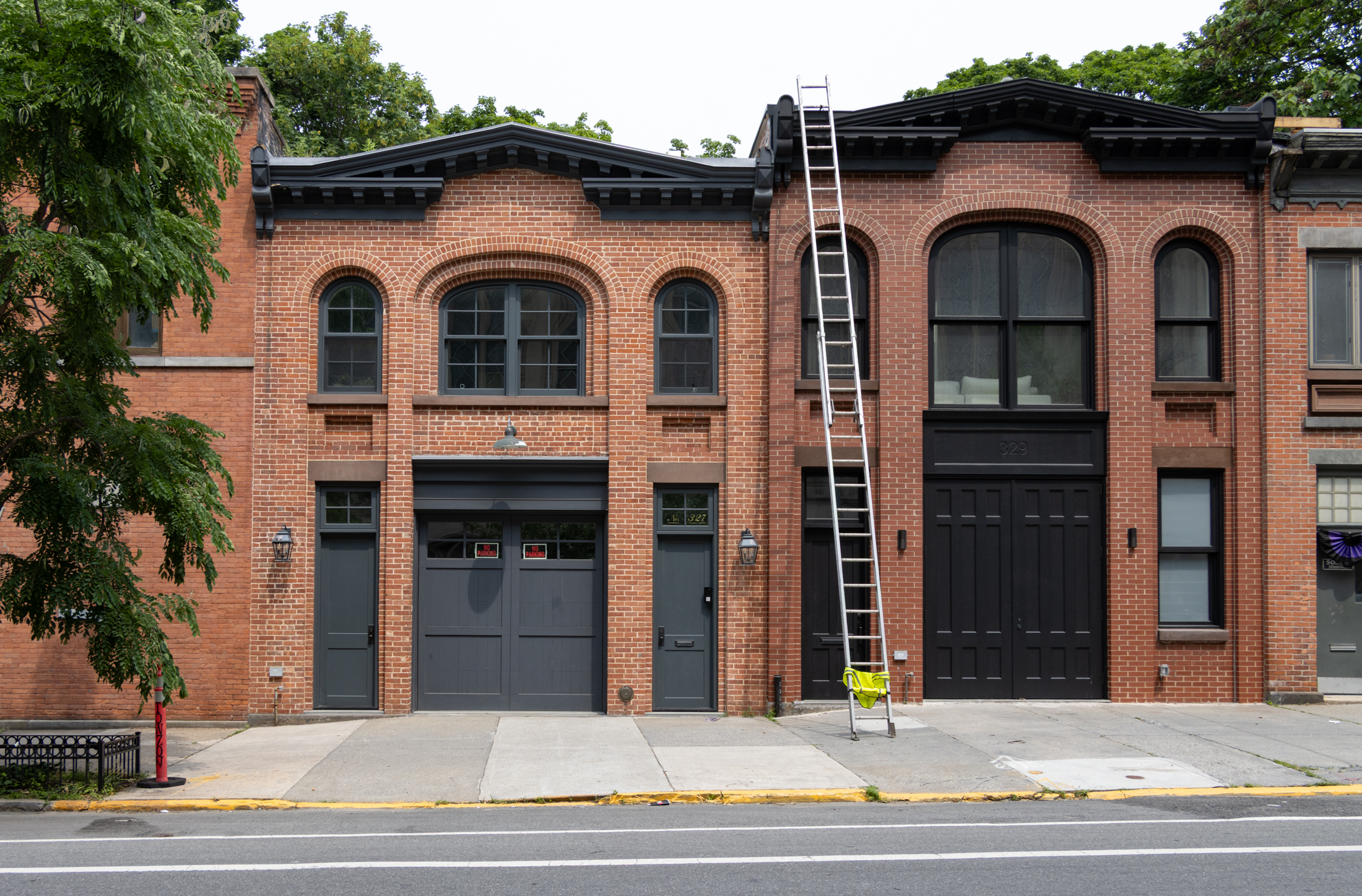 brick stable buildings, one with a tall ladder leading against it