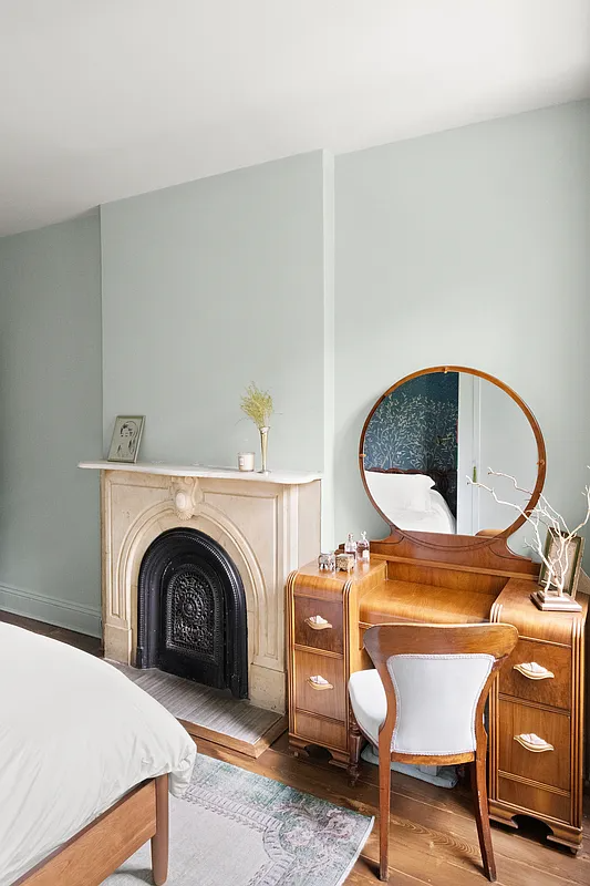 bedroom with marble mantel and pale blue walls