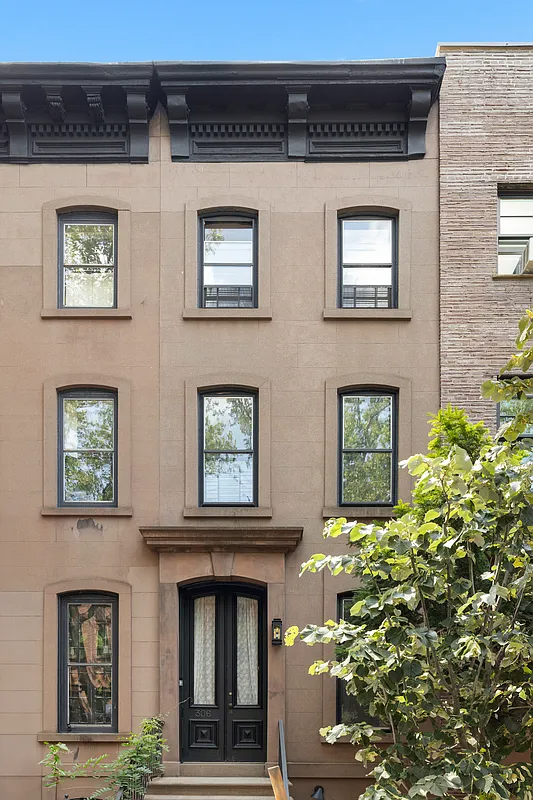 narrow brownstone exterior with a bracketed cornice