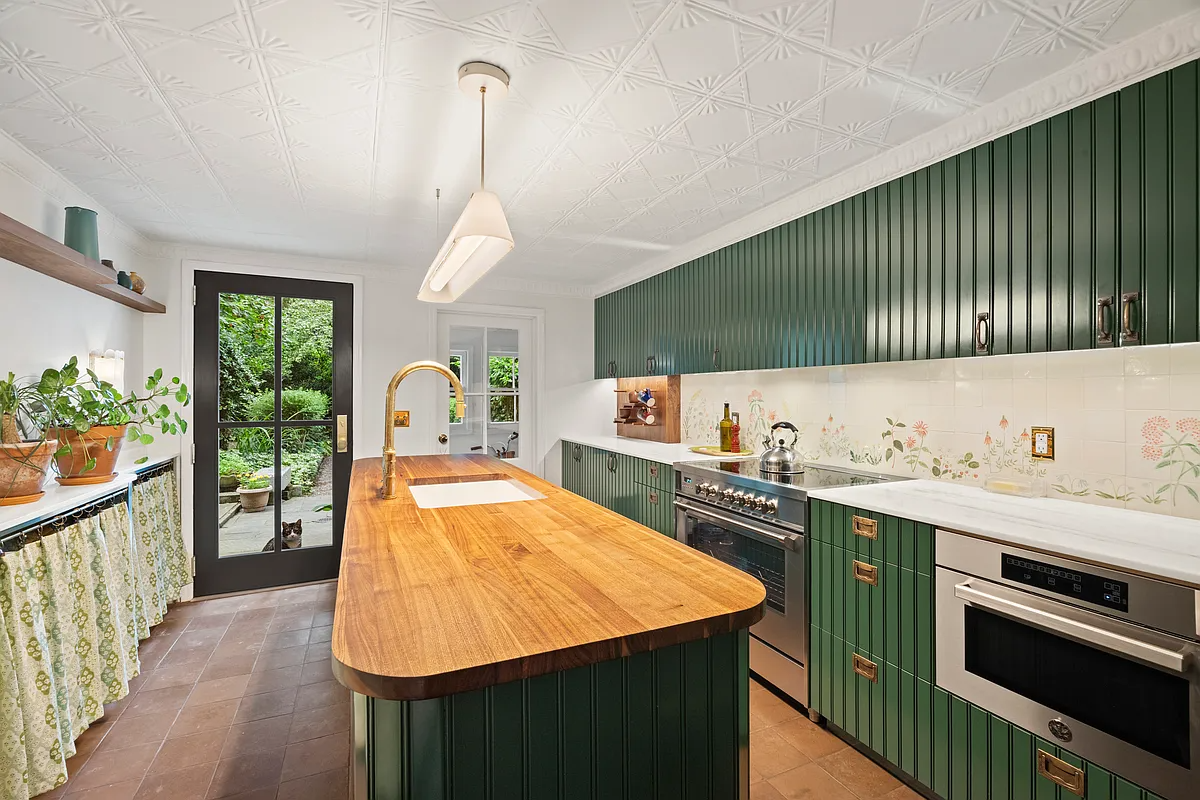 kitchen with green cabinets, tin ceiling, butcher block island