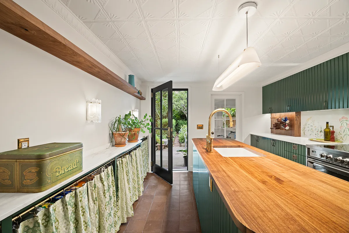 kitchen with green cabinets, tin ceiling, butcher block island
