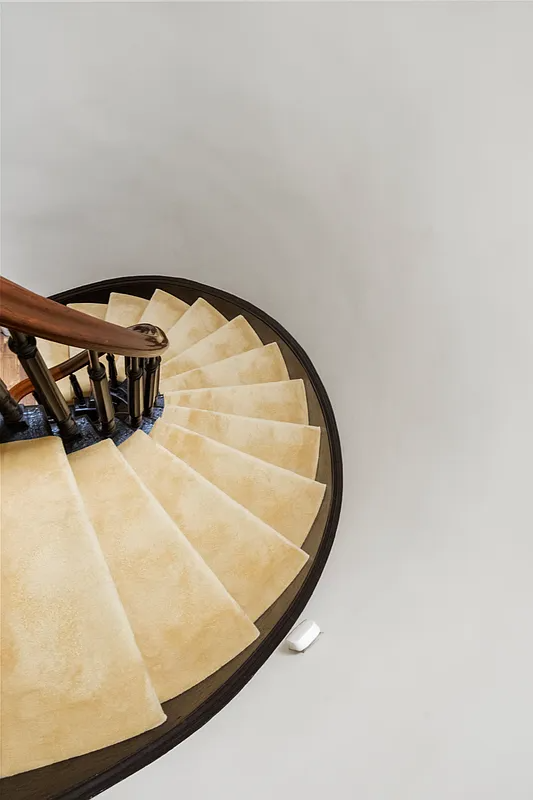 detail of curved staircase with carpeted steps