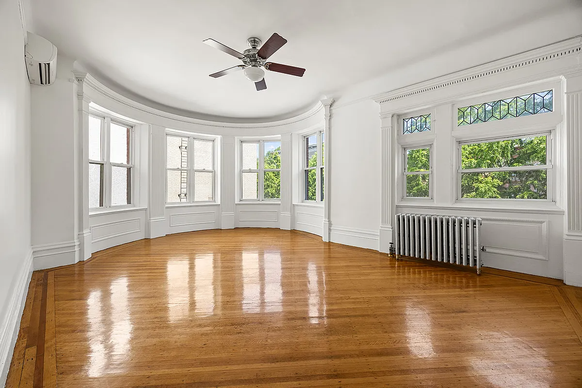 bedroom with curved bay and a ceiling fan