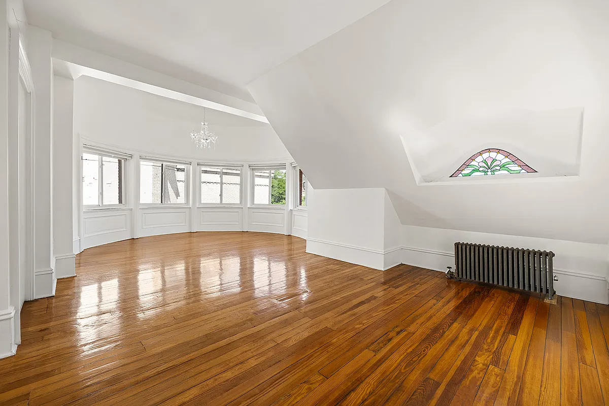 bedroom with stained glass eyebrow window, wood floor