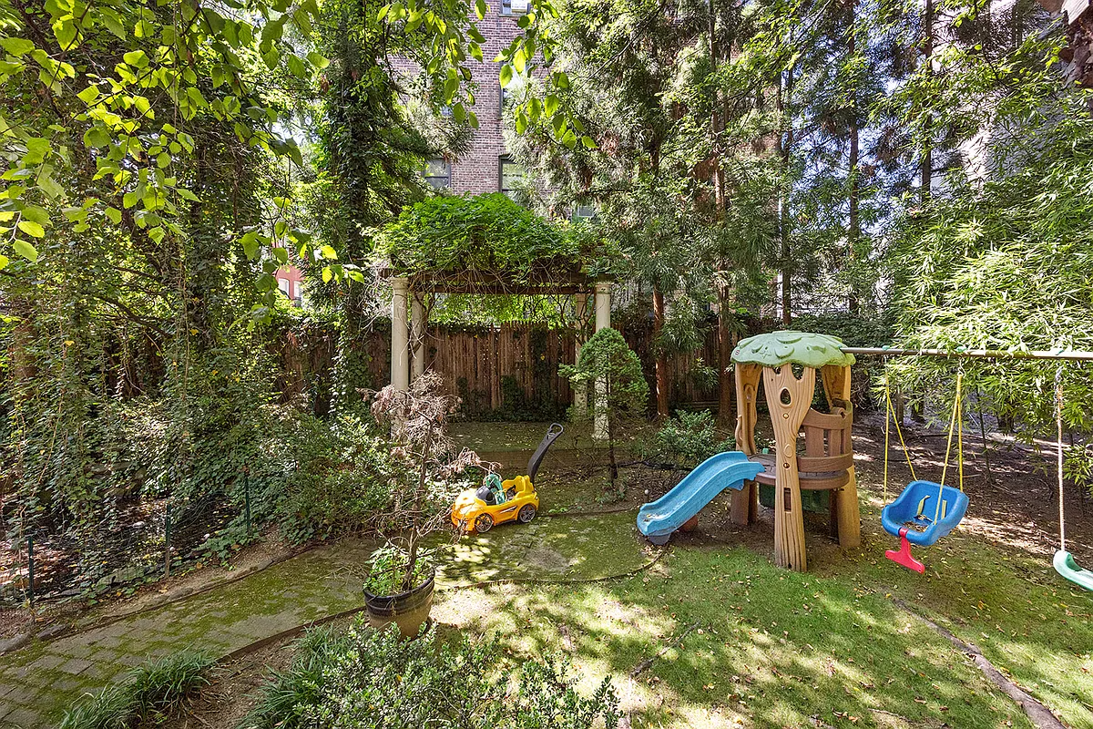 rear yard with a pergola, plantings and play equipment