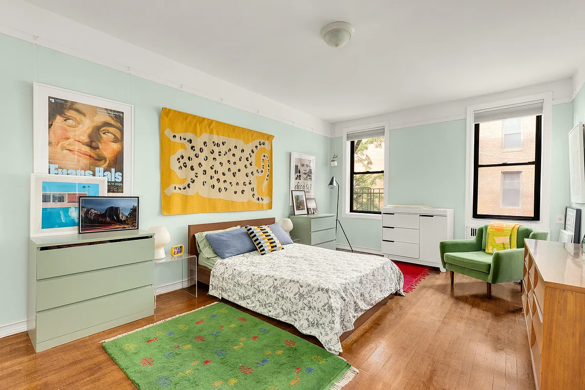 bedroom with pale green walls, picture rail, wood floor
