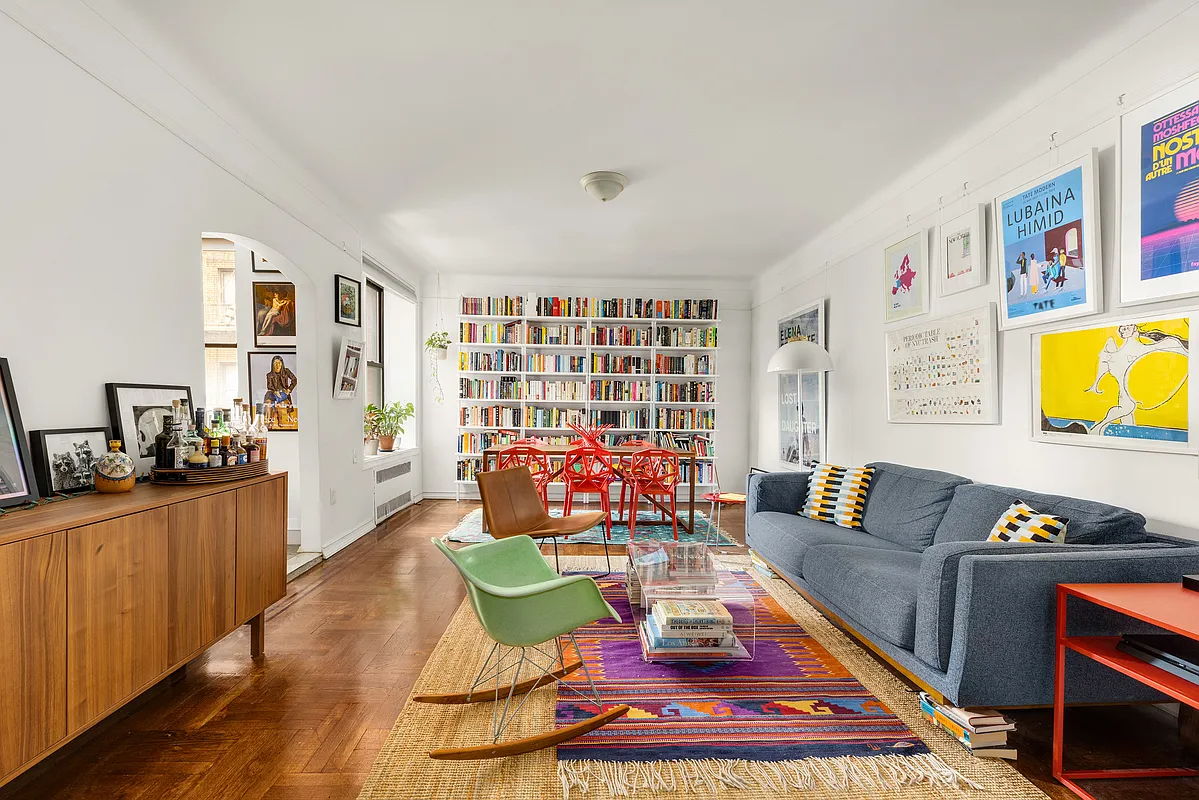 living room with picture rails, wood floor, arched doorway to kitchen