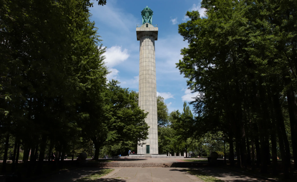 trees shading a walkway leading to the massive column, the martyrs monument in fort greene park