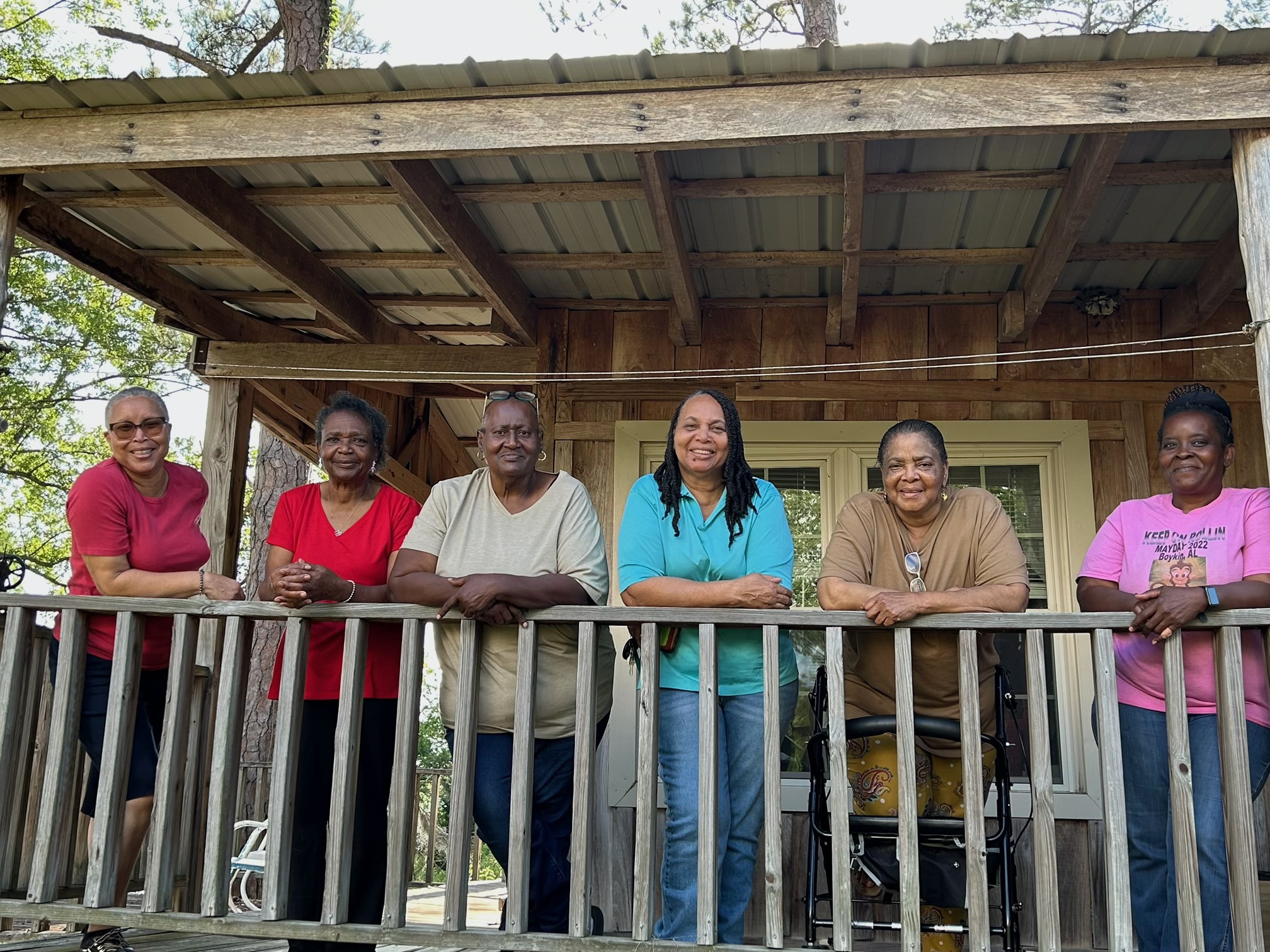 people lined up and posing on a porch