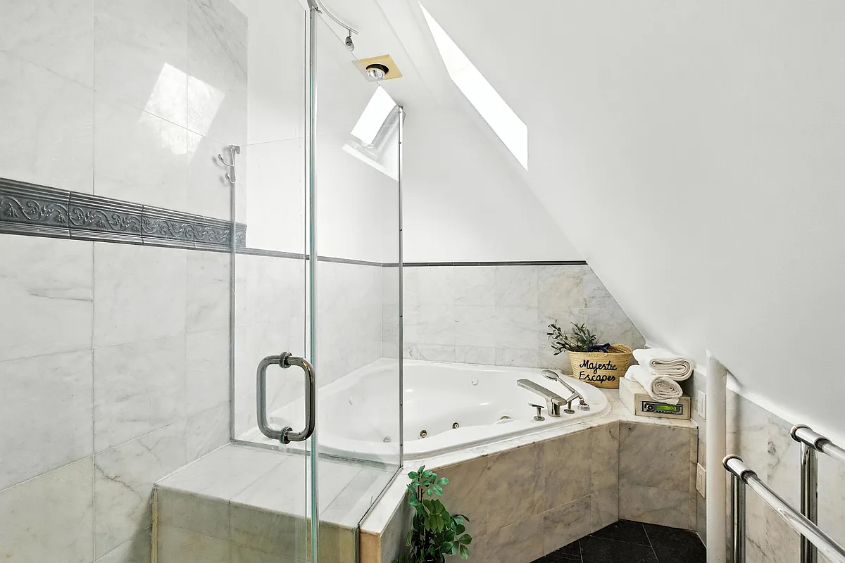 bathroom with a skylight above a tub and with a shower