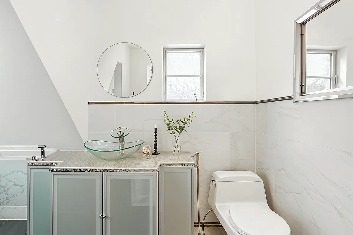 bathroom with marble tile on walls and a vanity with a vessel sink