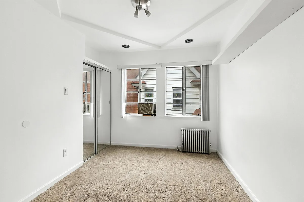 a bedroom with carpet, mirrored closet doors, and a ceiling fan