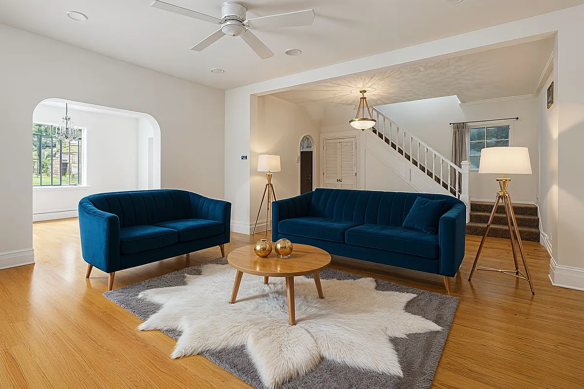 a virtually staged living room with two sofas and a ceiling fan