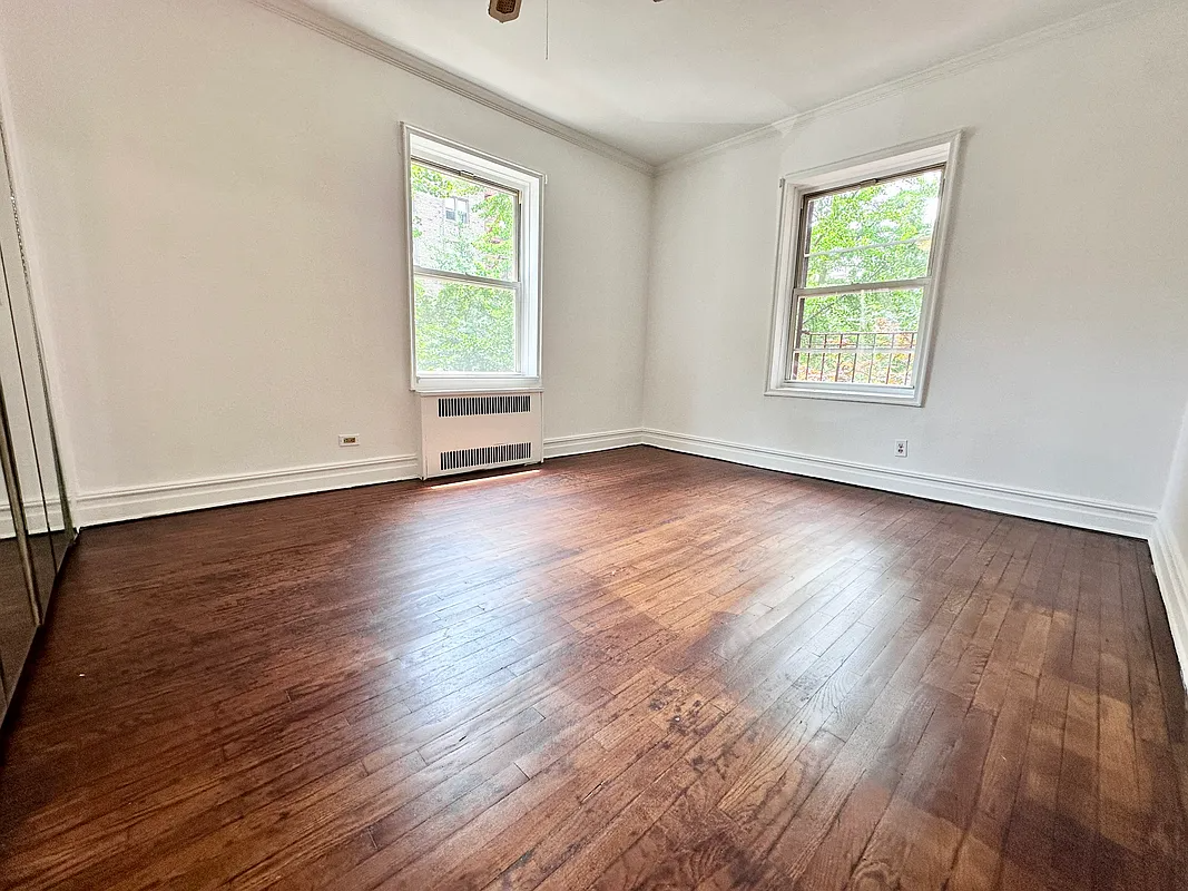 bedroom with wood floor, two exposures