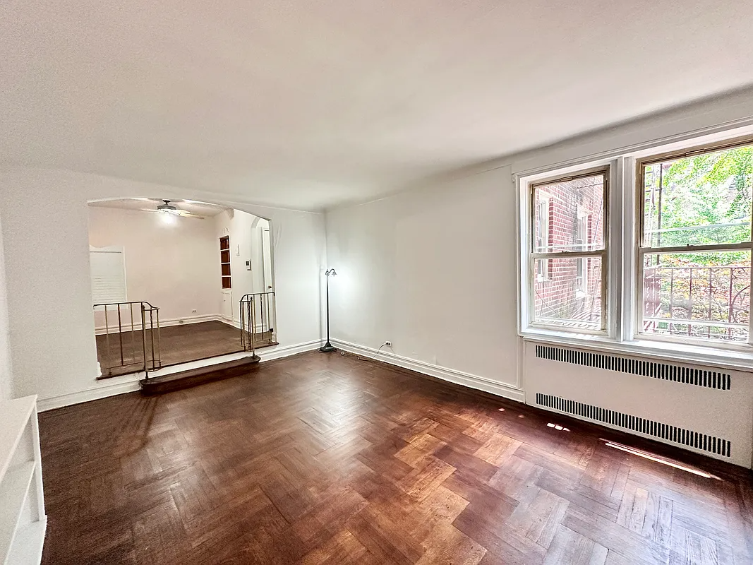a sunken living room with a wood floor, curved railings