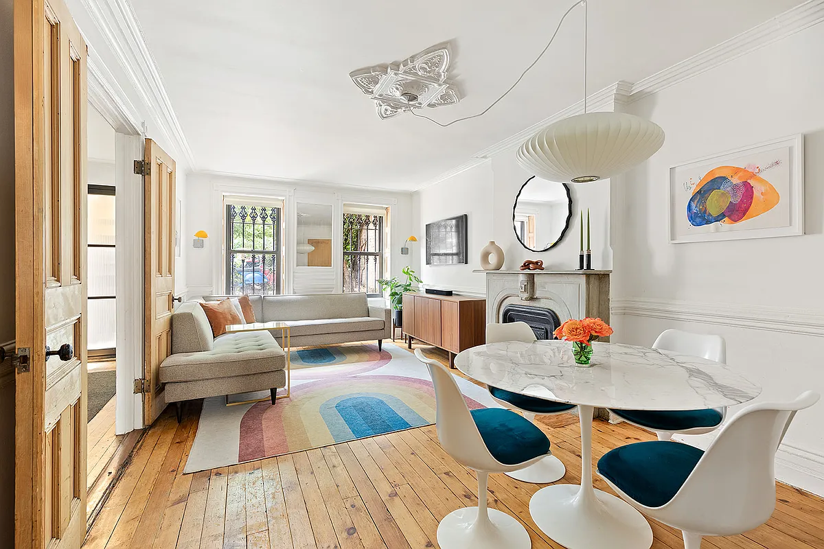 a garden level living room with wood floors, white walls