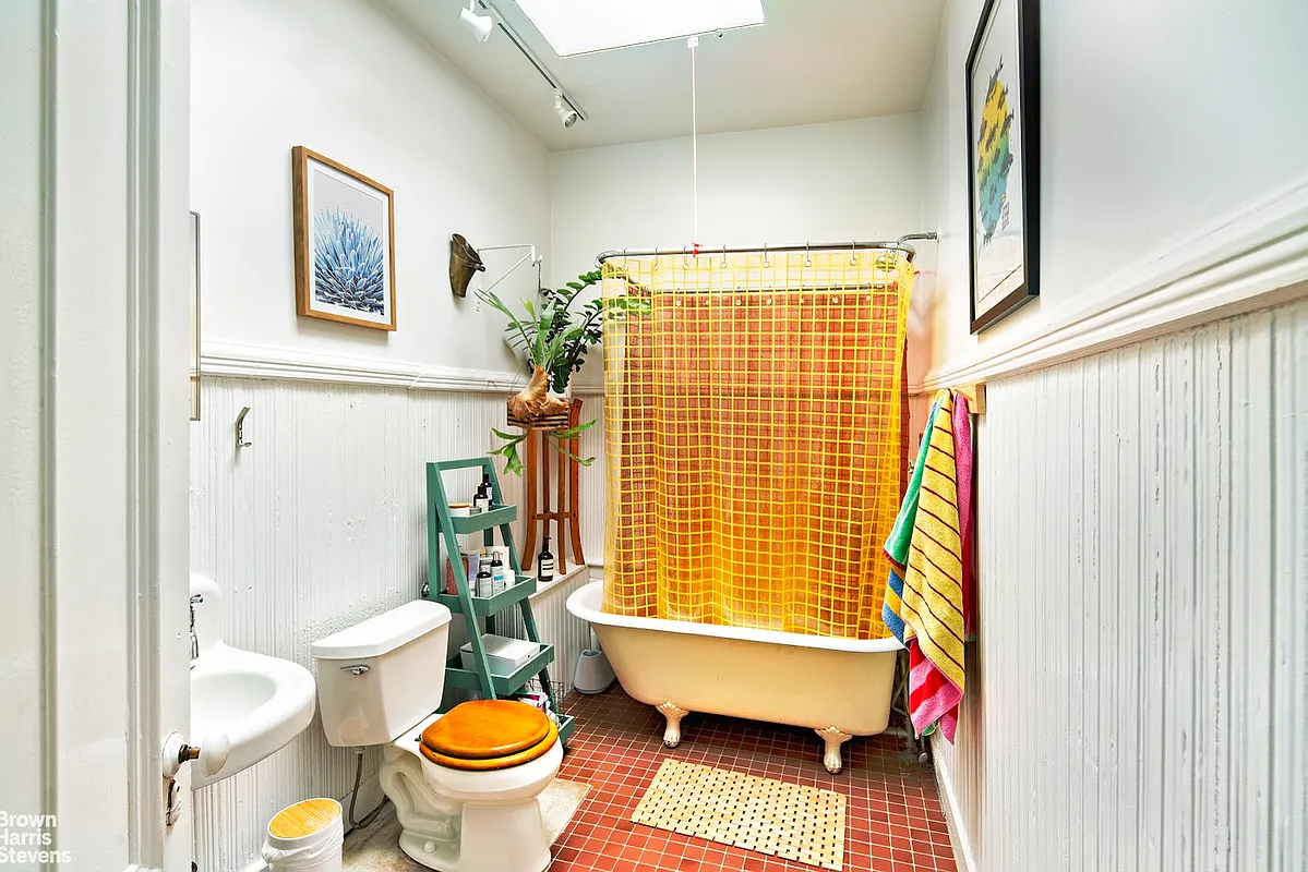 park slope - a bathroom with a skylight, white painted beadboard and a claw foot tub