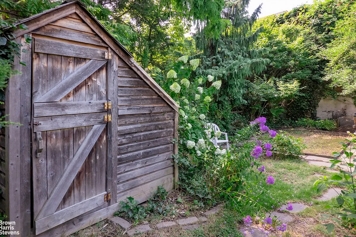 rear yard with a wood shed, stone path, hydrangeas