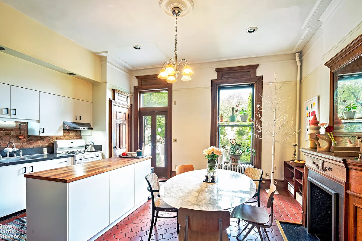 park slope - kitchen with terra cotta tile floor, a wood mantel, and white cabinets