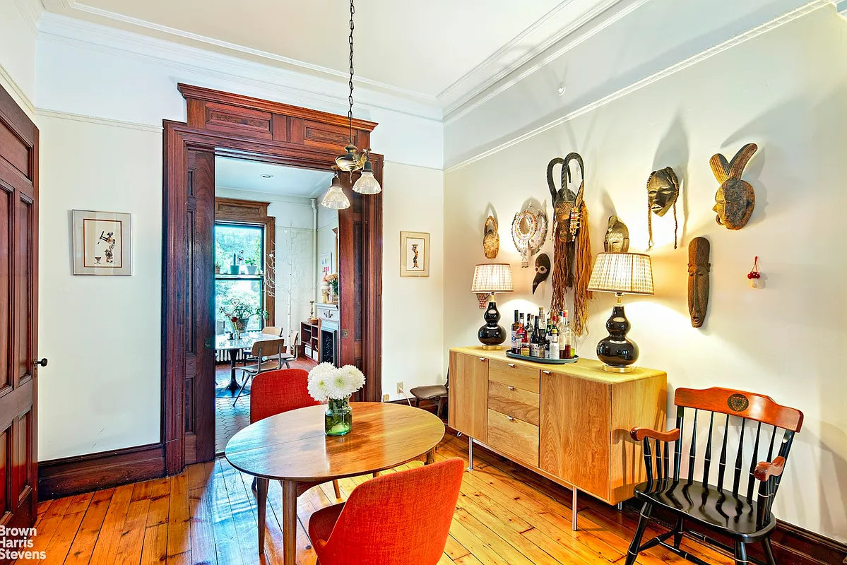 parlor with wood floor, moldings, and pocket doors to kitchen